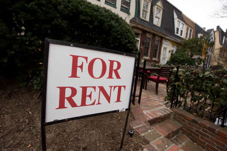 Close-up. A Pho Rent sign is glued to a fence in front of a residential building in downtown Washington DCのeditorial素材