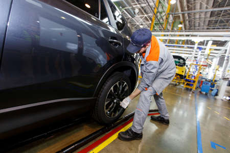 Summer, 2016 - Vladivostok, Primorsky Region - Sollers Automobile Plant in Vladivostok. The assembled car is on the conveyor belt. Factory workers inspect a new car.のeditorial素材