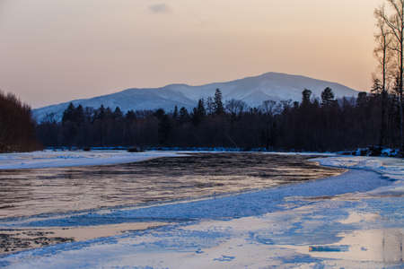 Northern landscape of Primorsky Territory, Samarga River. Frozen river in the taiga against the...
