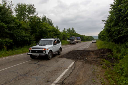 Summer, 2016 - Primorsky Krai, Russia - The car drives on a bad asphalt road. Killed Russian roadsのeditorial素材