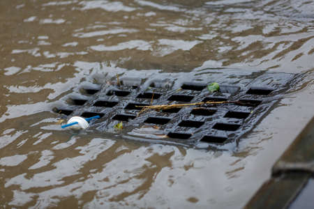 Dirty rainwater drains into a road rain storm