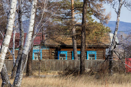 An old one-story wooden house with carved shutters in the Russian style. Wooden house on the street of a Russian townの写真素材