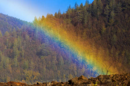 The nature of the Magadan region. Beautiful rainbow on the background of autumn hillsの写真素材