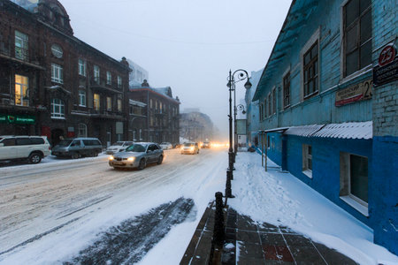 January, 2016 - Vladivostok, Russia - Heavy snowfall in Vladivostok. Cars drive during snowfall along the central streets of Vladivostok.のeditorial素材
