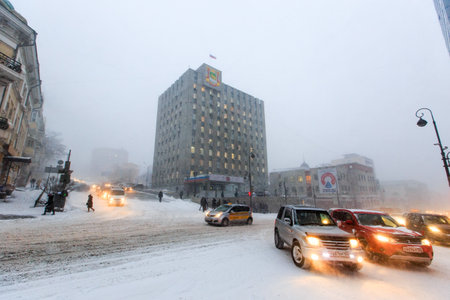 January, 2016 - Vladivostok, Russia - Heavy snowfall in Vladivostok. Cars drive during snowfall along the central streets of Vladivostok.のeditorial素材