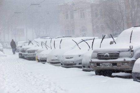 January, 2016 - Vladivostok, Russia - Heavy snowfall in Vladivostok. Snow-covered cars stand along the roadside during heavy snowのeditorial素材