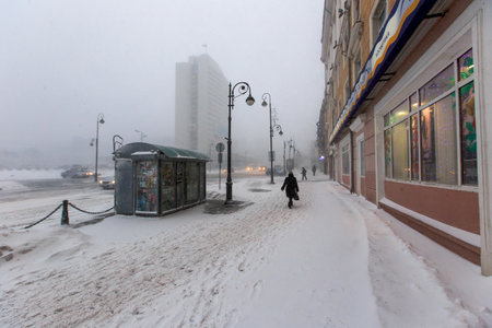 January, 2016 - Vladivostok, Russia - Heavy snowfall in Vladivostok. People walk along the central streets of Vladivostok covered with snow. Pedestrians walk past large snowdrifts through the cityのeditorial素材