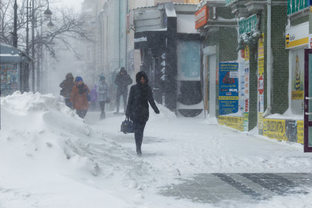 January, 2016 - Vladivostok, Russia - Heavy snowfall in Vladivostok. People walk along the central streets of Vladivostok covered with snow. Pedestrians walk past large snowdrifts through the cityのeditorial素材