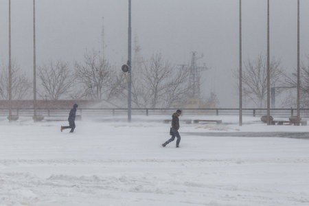 January, 2016 - Vladivostok, Russia - Heavy snowfall in Vladivostok. Lonely man walks past the inscription Happy New Year during heavy snowfallのeditorial素材