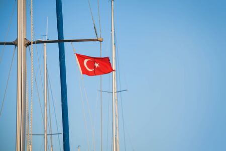 Ship mast with the Turkish flag over blue sky backgroundの写真素材