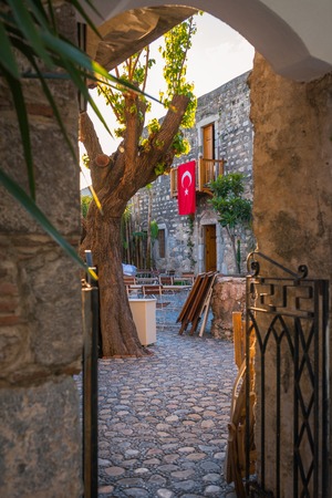 Old narrow street in Turkey, from the balcony of the old house hanging flagの写真素材