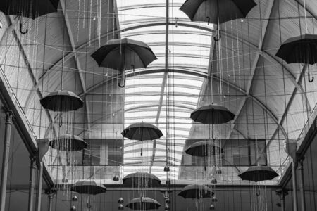 Monochrome umbrellas hang from the ceiling in a beautiful roomの写真素材