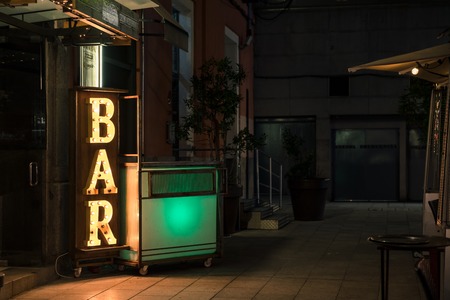Bar Electric Light Sign On The Buildings Exterior On Dark Night Time In The city