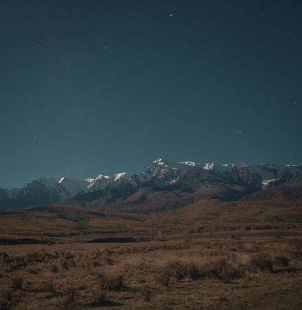 Beautiful autumn landscape with mountains covered with snowの写真素材