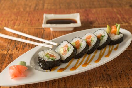 Eight pieces of sushi on a plate with chopsticks and soy sauceの写真素材