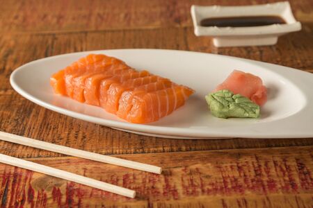 Eight pieces of sushi on a plate with chopsticks and soy sauceの写真素材