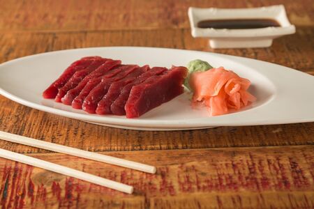 Eight pieces of sushi on a plate with chopsticks and soy sauceの写真素材