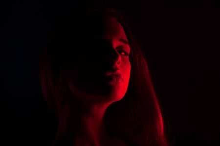 Young beautiful woman in lingerie posing in red back light