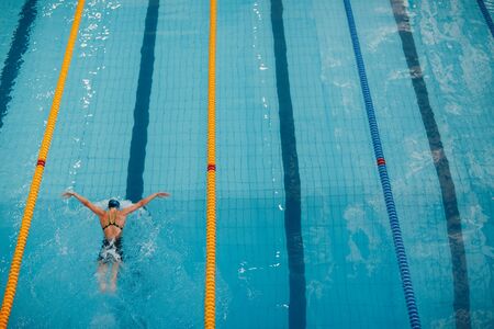 Young woman swimmer swims in swimming poolの写真素材