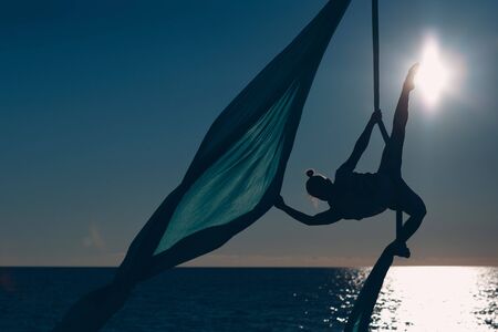 Air yoga on the beach. Healthy Woman.の写真素材