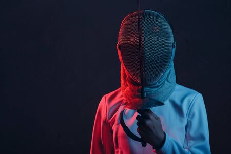 Fencer woman in mask profile portrait with fencing sword, rapier, epee.の写真素材