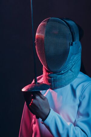 Fencer woman with fencing epee saber sword. Color light.の写真素材
