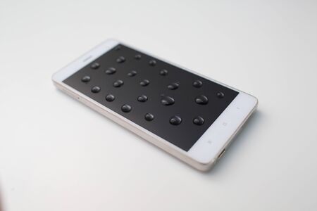 Mobile phone with drops on oleophobic screen