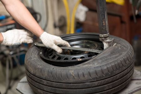 Mechanic changing car tire fitting. Wheel tyre repairing.の写真素材