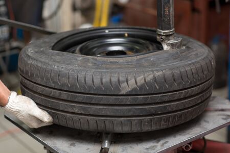 Mechanic changing car tire fitting. Wheel tyre repairing.の写真素材