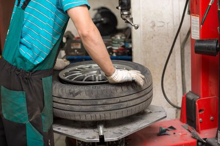 Mechanic man changing car tire fitting. Wheel tyre repairingの写真素材