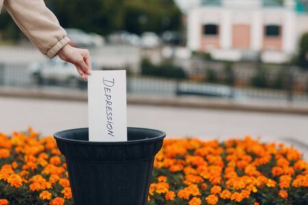 Woman throws sheet with word depression into trash can. Psychology helpの写真素材