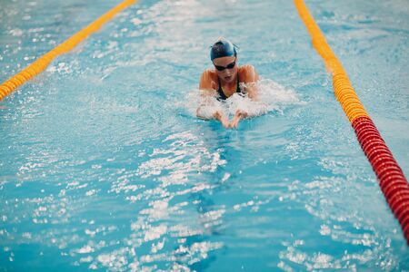 Young woman swimmer swims in swimming pool. Motion blurの写真素材