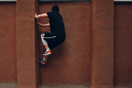 Young sporty guy doing parkour at the city street.の写真素材