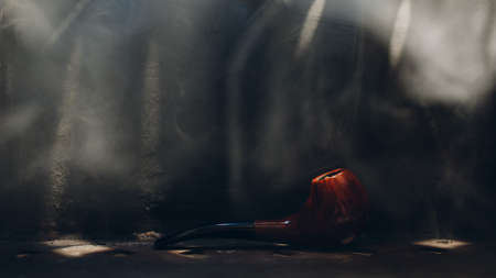 Smoking pipe on steel background with smoke.の写真素材