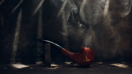 Smoking pipe on steel background with smoke.