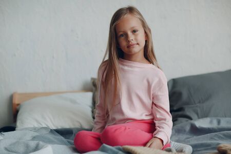 Little girl child in pink clothes portrait at home.の写真素材