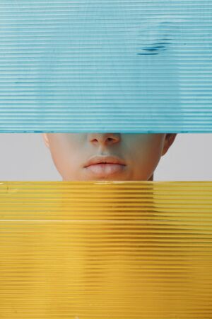 Portrait of young beautiful positive woman with nude make up and colorful lightの写真素材