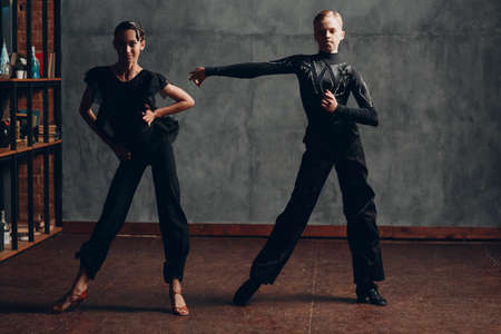 Young couple dancing in ballroom dance cha cha.