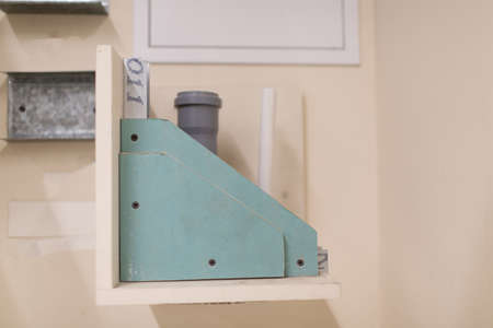Grey pipe attached in drywall wall example.