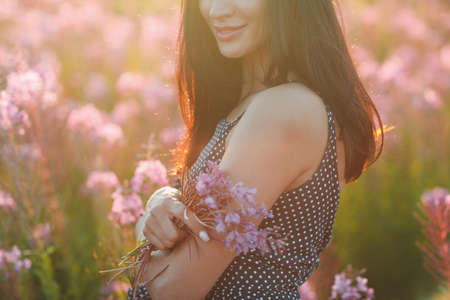Girl on blooming Sally flower field. Lilac flowers and woman.の写真素材