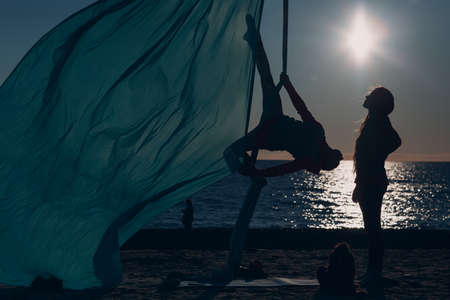 Aerial yoga on the beach. Healthy Woman.の写真素材