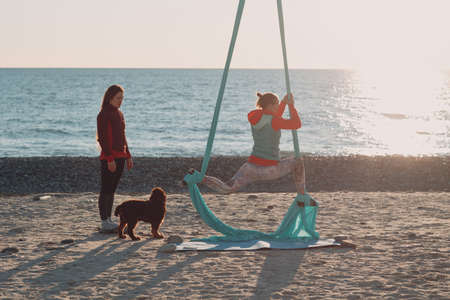 Aerial yoga on the beach. Healthy Woman.の写真素材