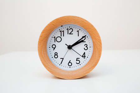Wooden alarm clock on white table backgroundの写真素材