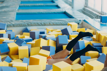 Young and beautiful woman plays in dry pool with cubesの写真素材