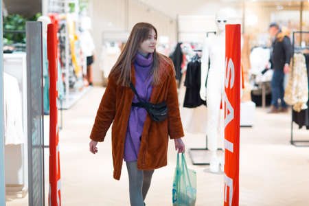 Young woman goes through a security anti-theft framework in a store.の写真素材