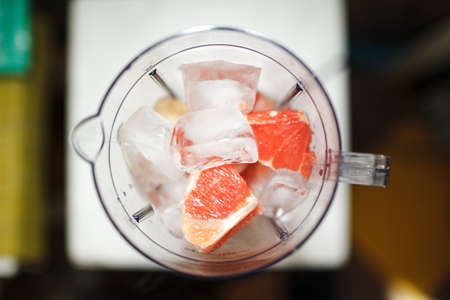 Grapefruit smoothie with ice in blender, diet and healthy eating conceptの写真素材