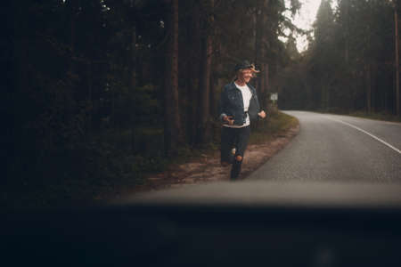 Woman running on the road at forest after leaving carの写真素材