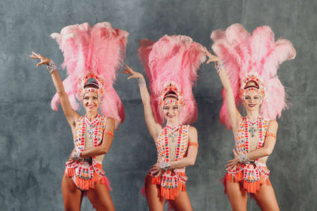 Three Women in samba or lambada costume with pink feathers plumage