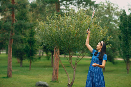 Young adult woman playing badminton in the parkの写真素材