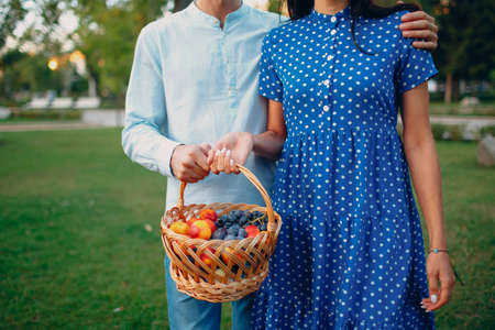 Close up of Happy Couple with Fruits in Picnic Basket Staying in the Park.